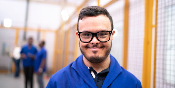 Retrato de sonriente empleado con necesidades especiales en la industria